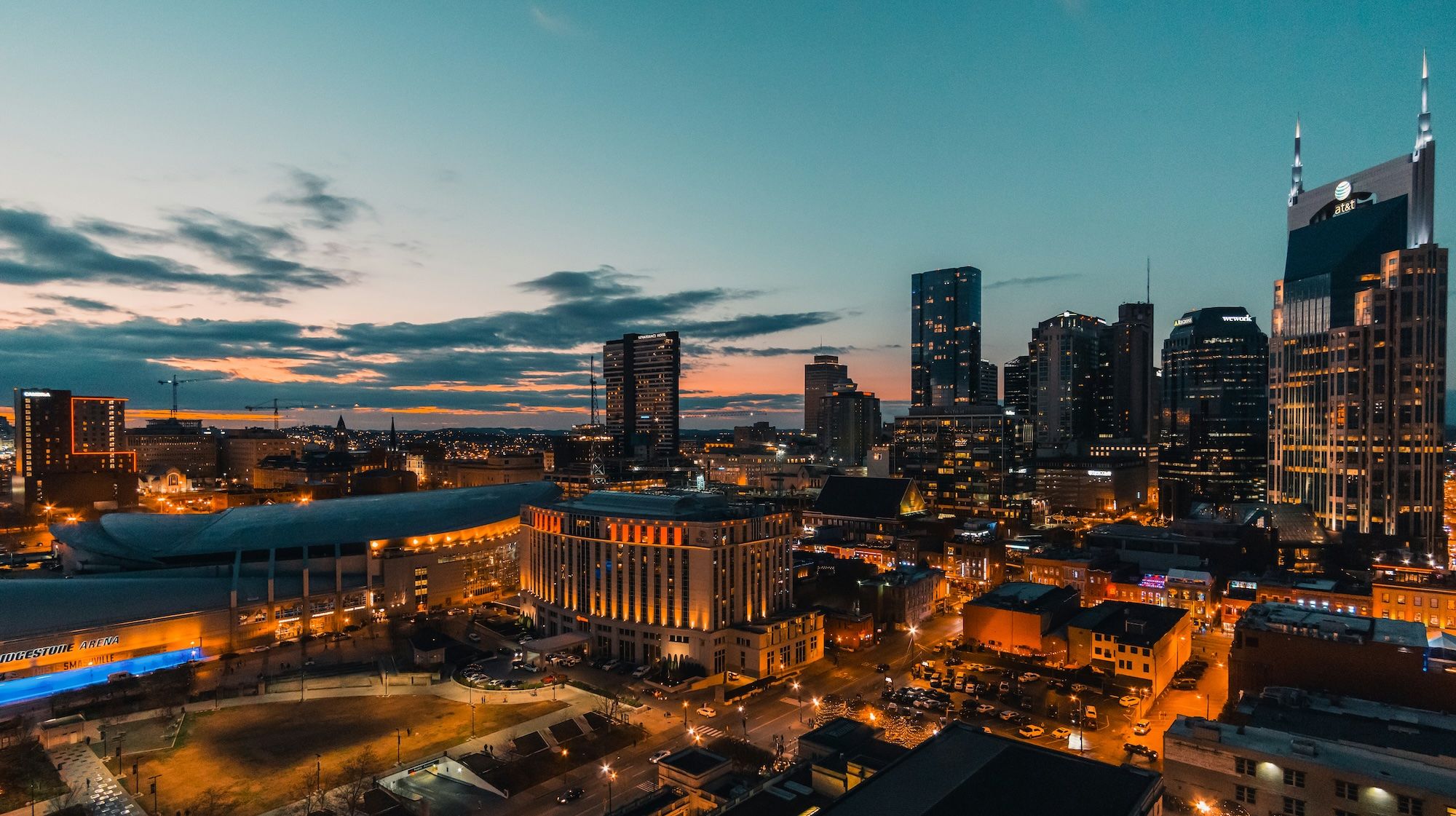Downtown Nashville skyline at dusk with city lights.