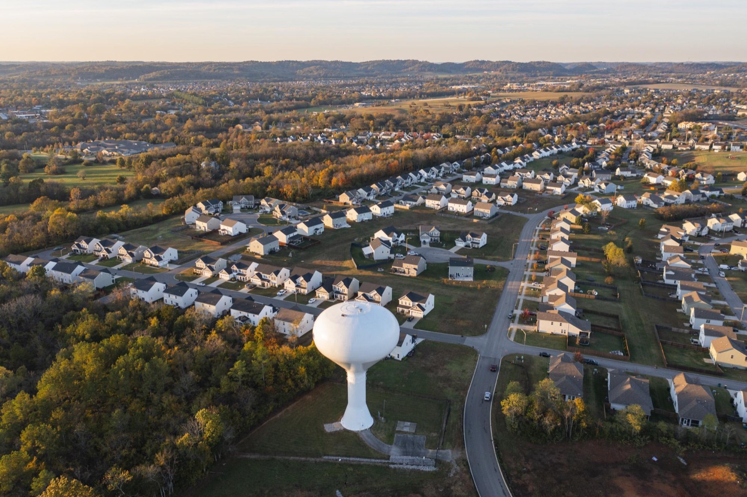 Aerial view of Spring Hill neighborhoods, fields, hills, and a water tower in Tennessee.